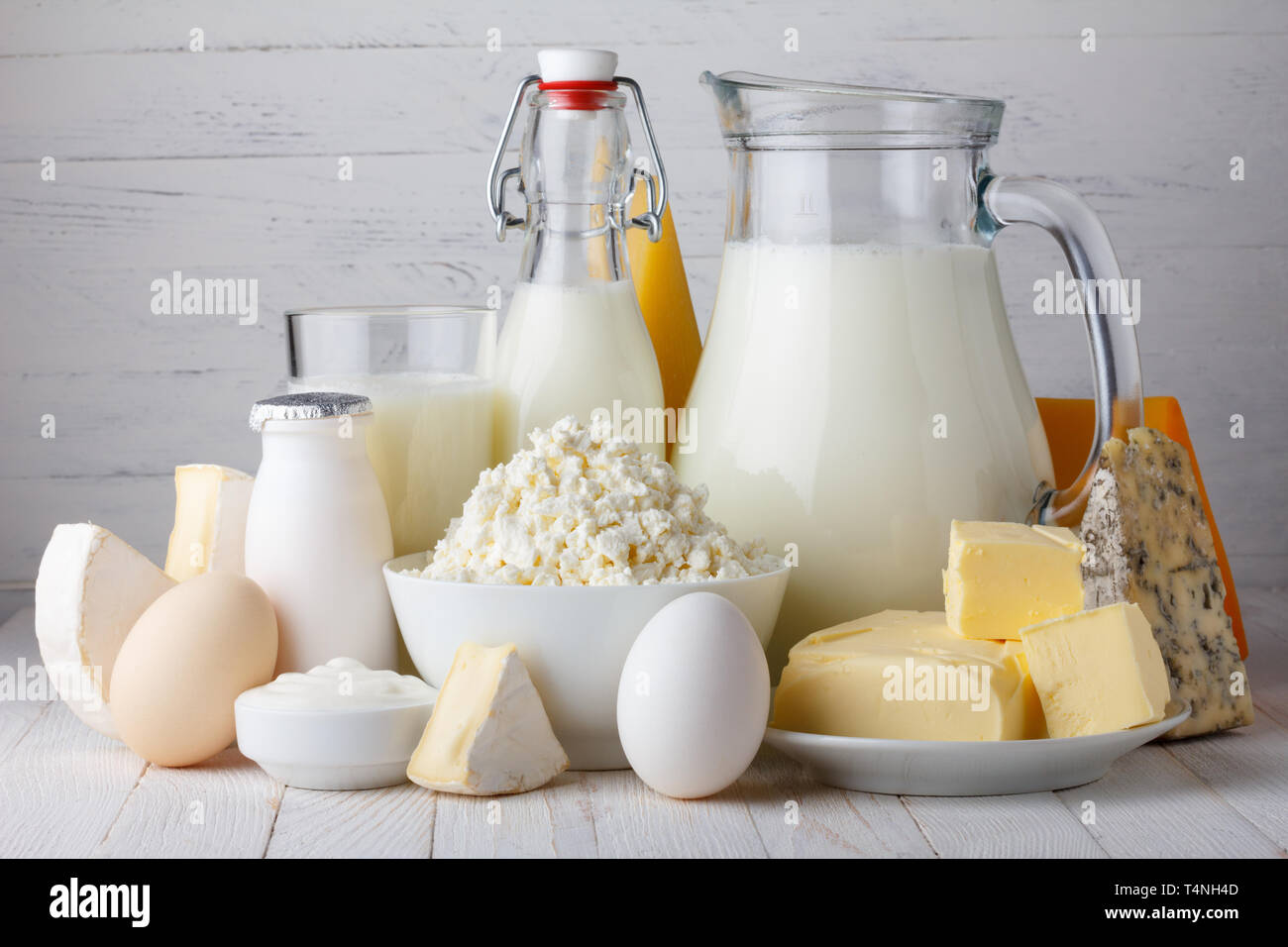 Dairy products, milk, cottage cheese, eggs, yogurt, sour cream and butter on wooden table Stock Photo