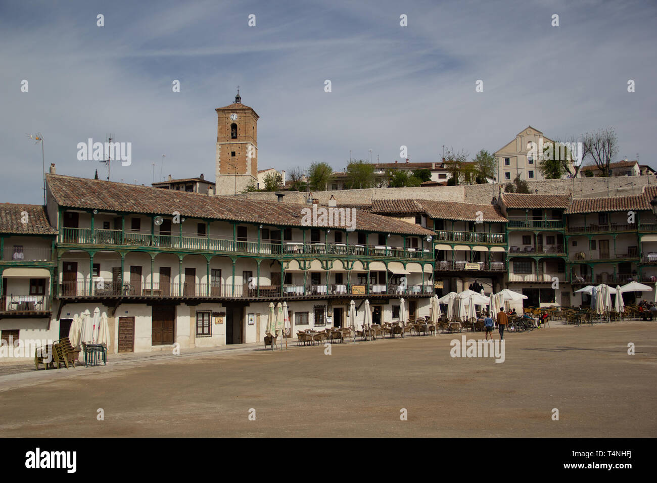 Chinchon, Spain - 04 14 2019: Buildings with green balconies and the clock tower in the background Stock Photo