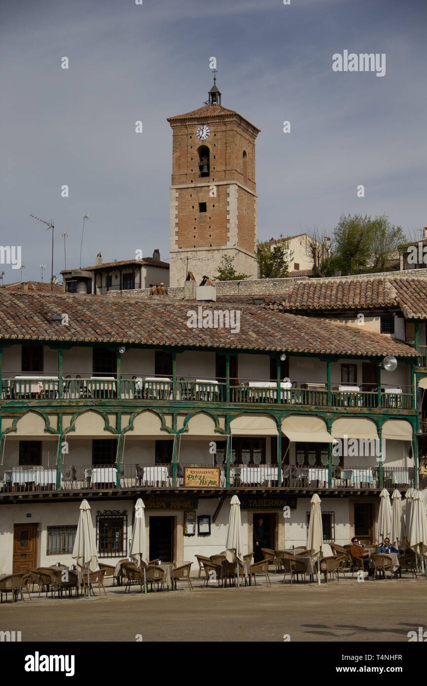 Chinchon, Spain - 04 14 2019: Building with green balconies from the main square and the clock tower in the background Stock Photo