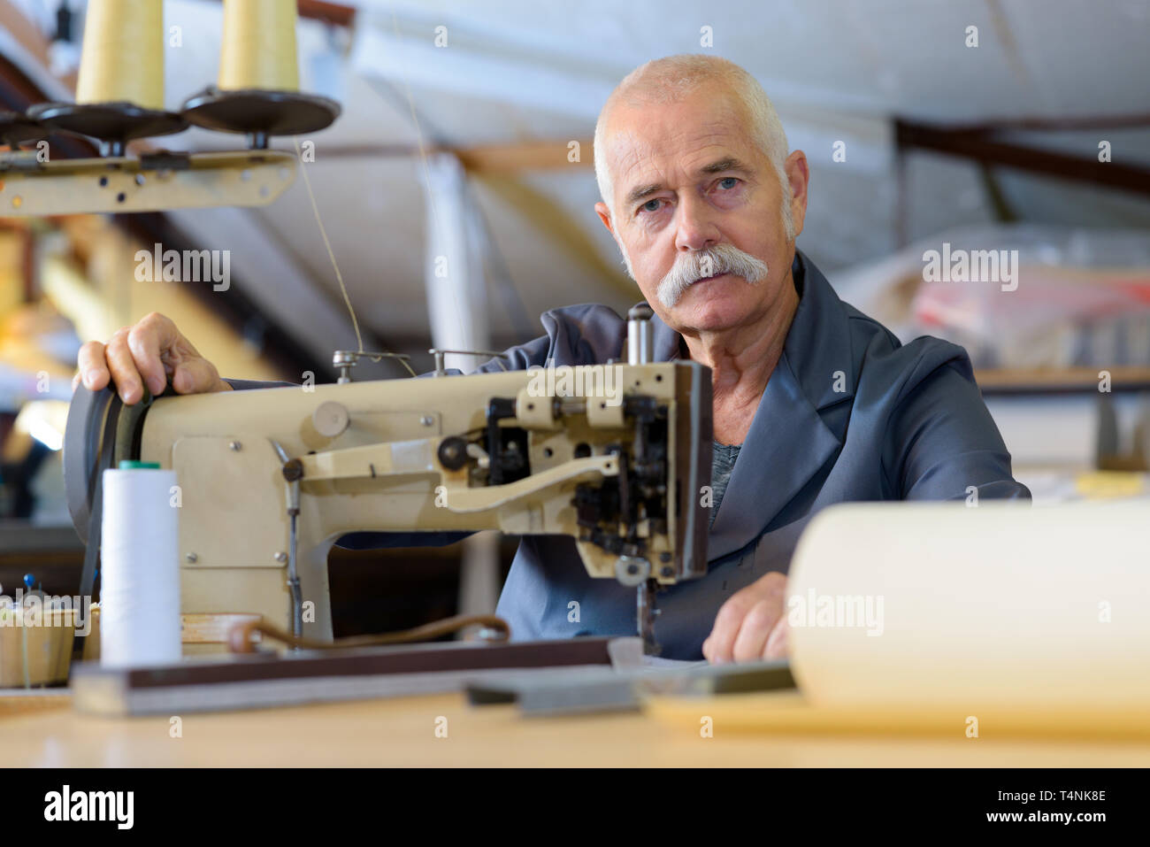 senior mechanic repairing industrial sewing machine Stock Photo Alamy