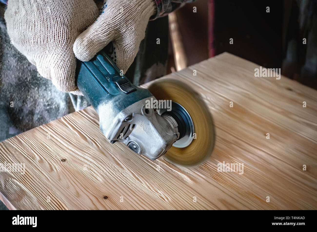 Hands of the master a drill and a brush clean wood and give it texture