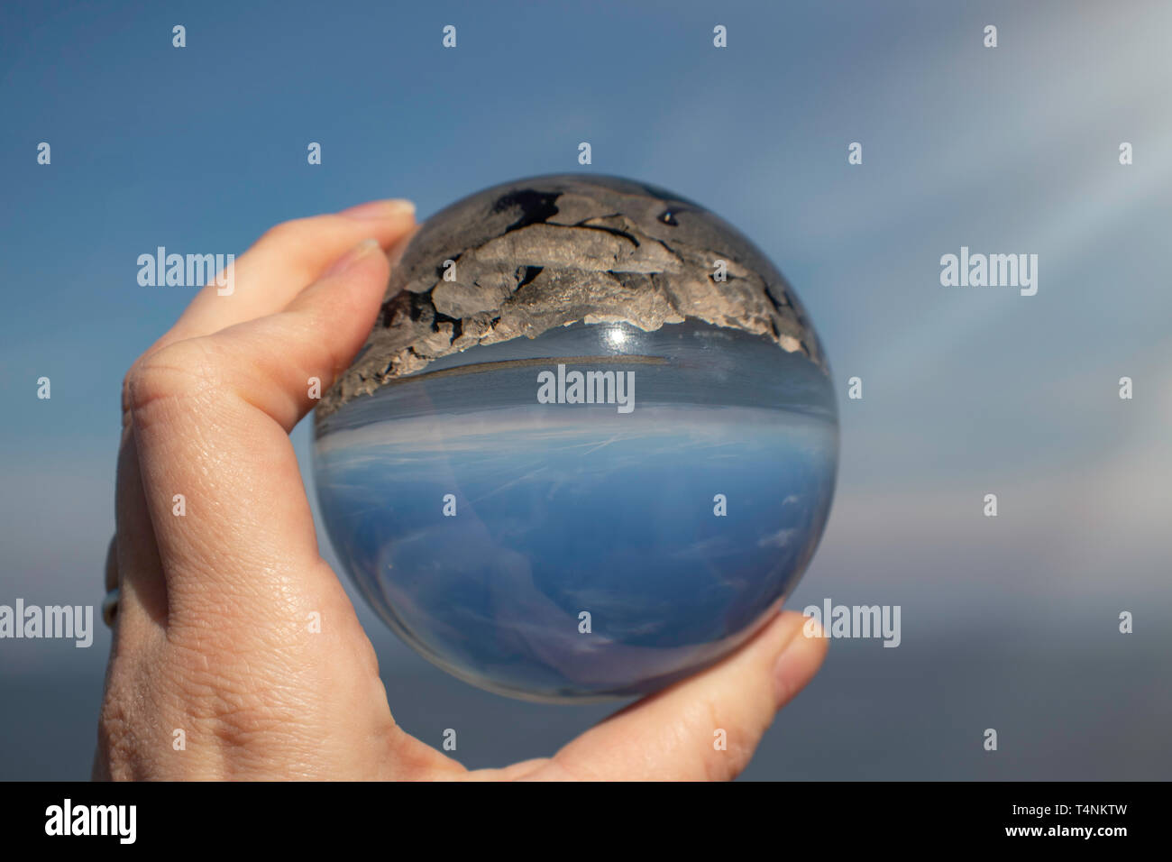 Morecambe Bay, Lancashire UK, as seen through a crystal photography ball held in a female hand - refraction photography, seascape Stock Photo