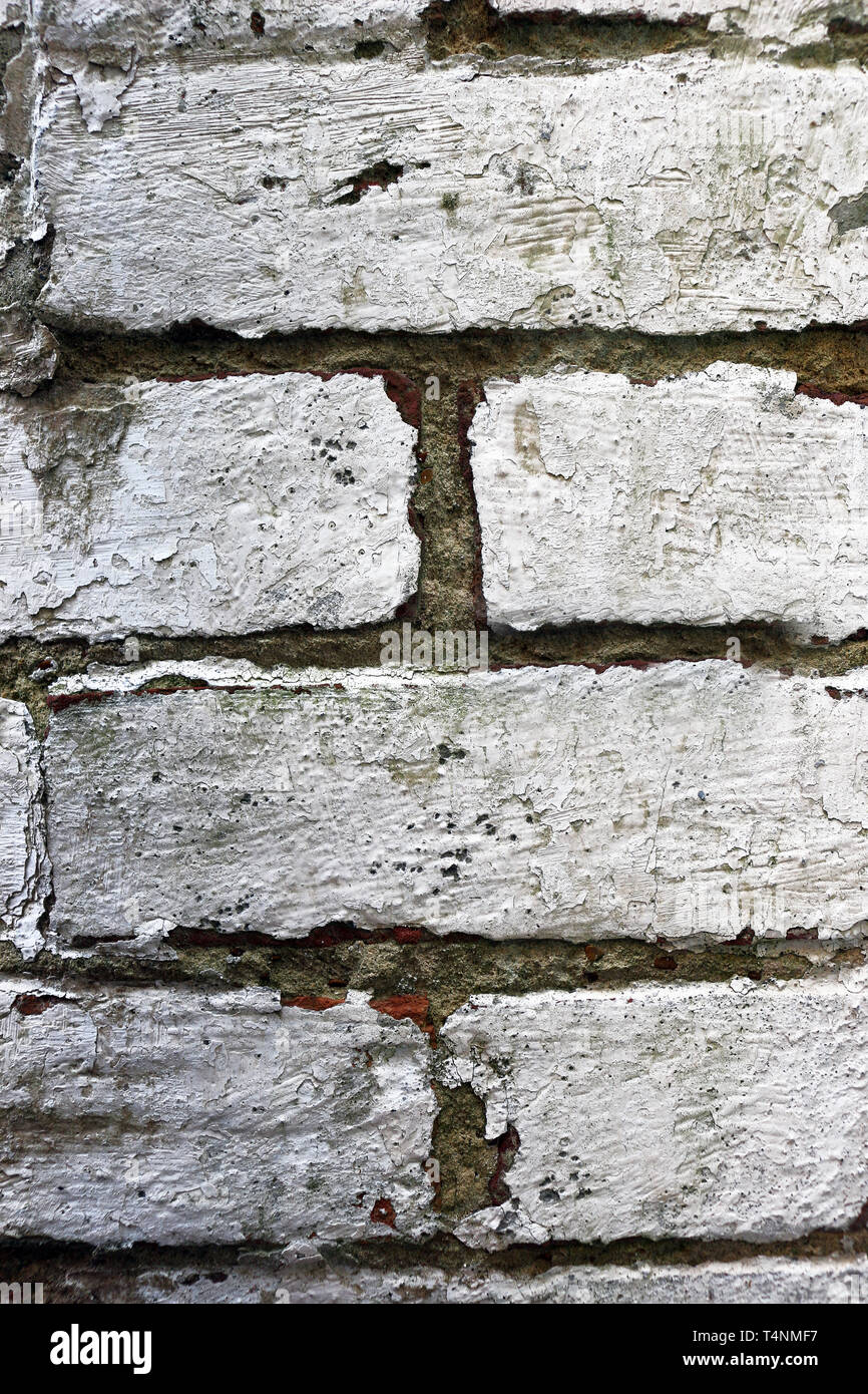 Pattern of a brick wall with peeling  white paint Stock Photo