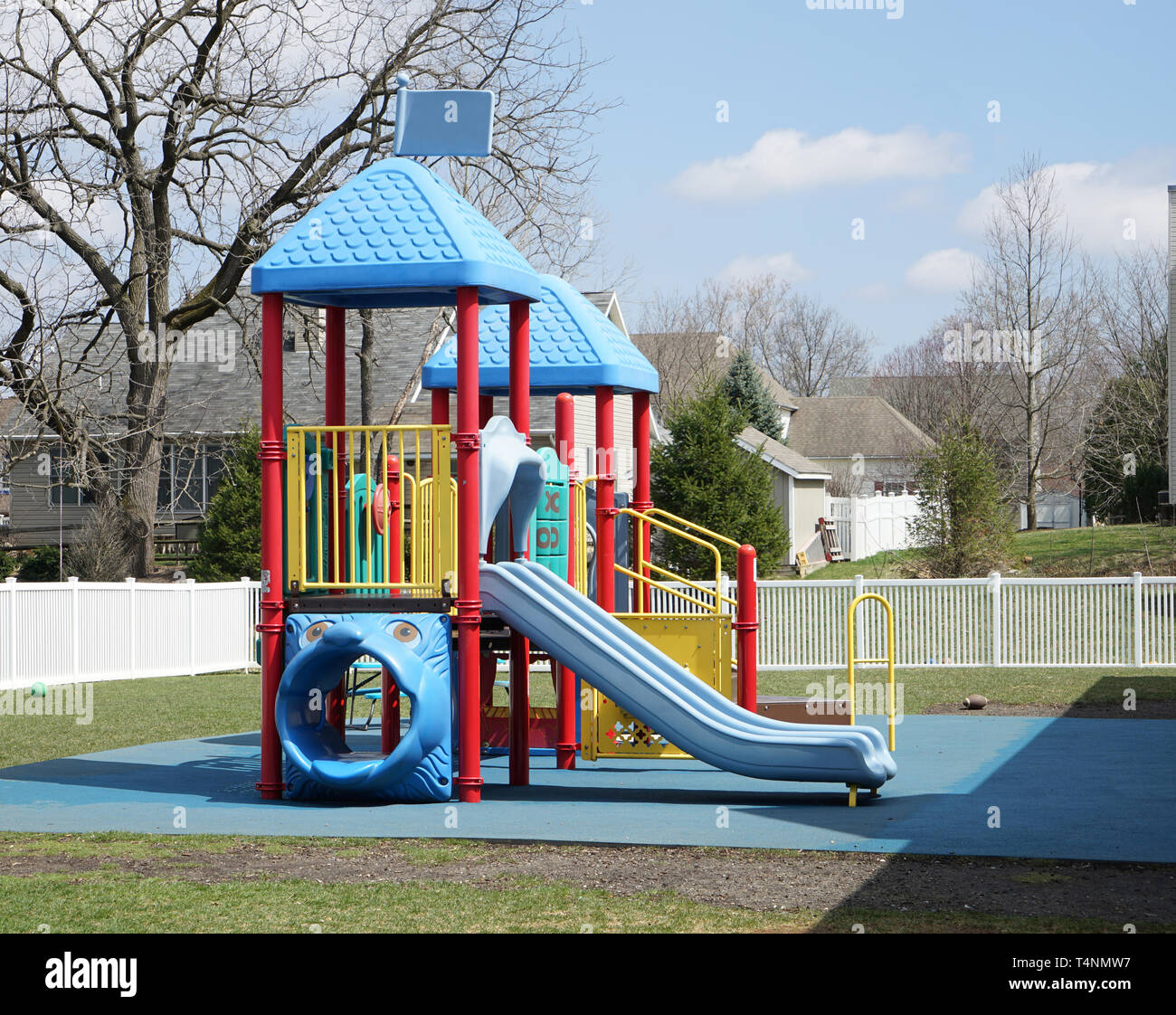 Outdoor play area with playground equipment. The area is surrounded by