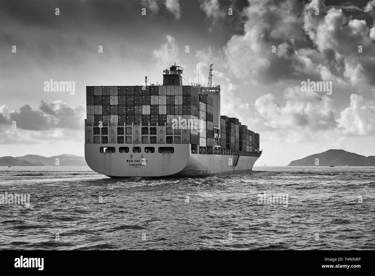 Moody Black and White Photo Of A WAN HAI LINES Container Ship, WAN HAI 501, Entering The East Lamma Channel As She Leaves Victoria Harbour, Hong Kong Stock Photo