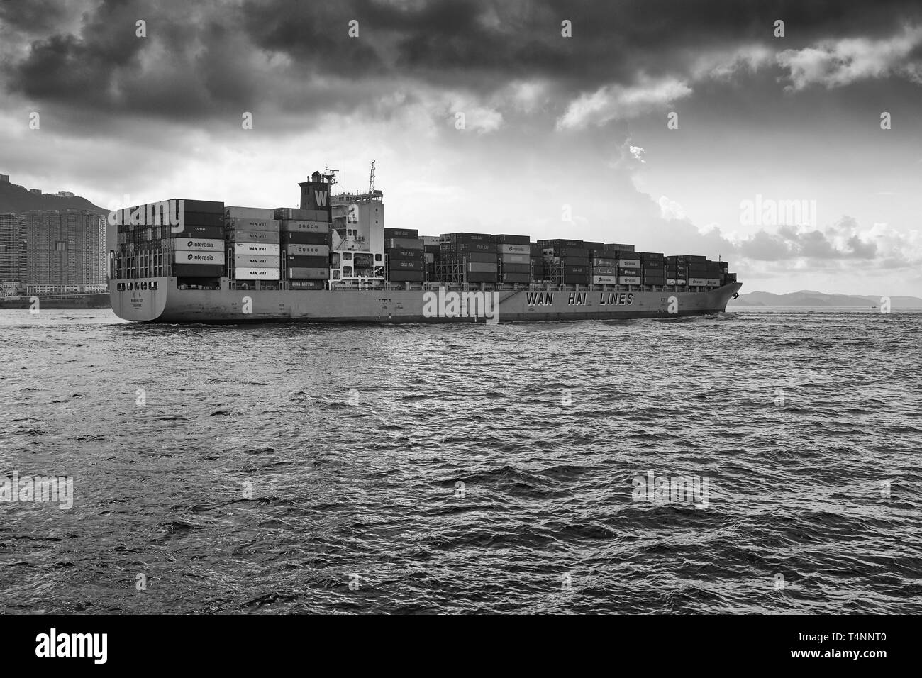 Black and White Photo Of A WAN HAI LINES Container Ship, WAN HAI 501, Entering The Busy East Lamma Channel As She Leaves Victoria Harbour, Hong Kong. Stock Photo