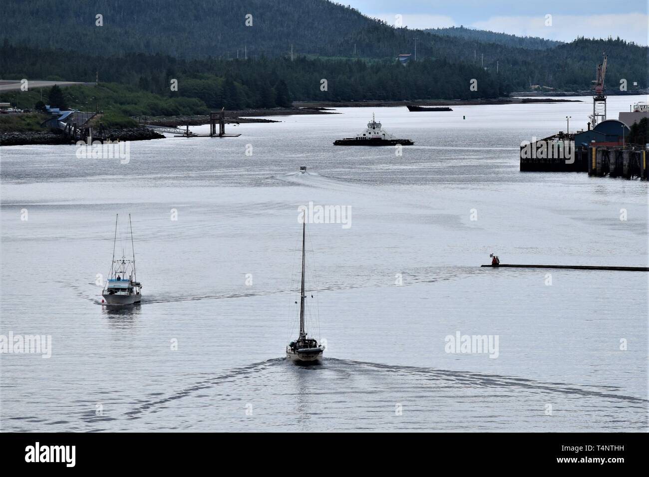 Various boats navigate the waters in an Alaskan port Stock Photo