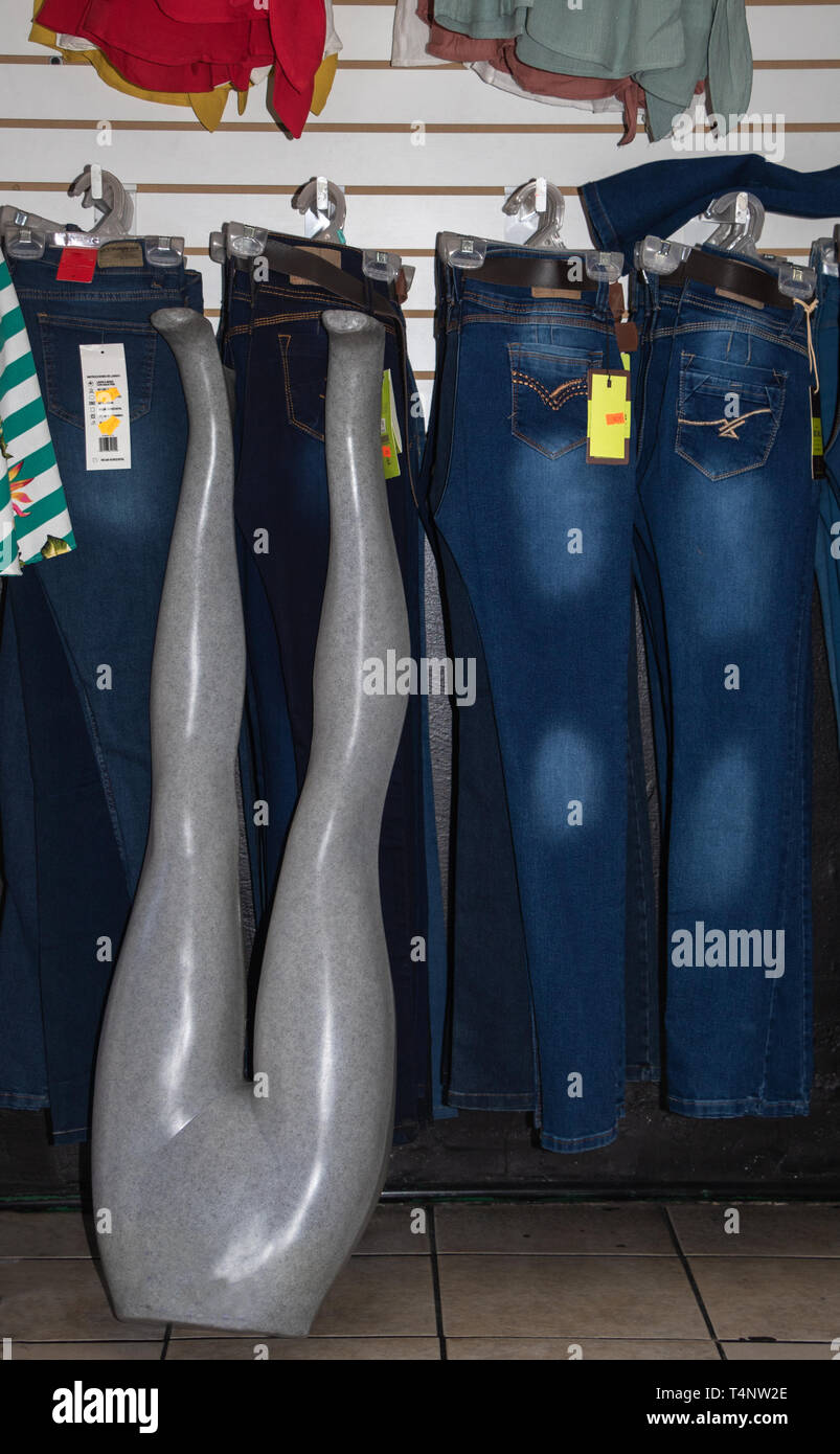 Mannequin legs propped up against a wall of jeans on display Stock Photo