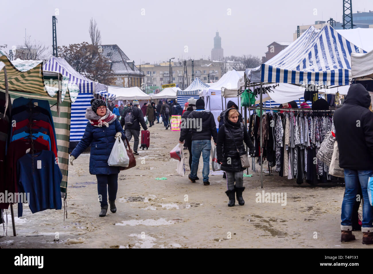 Customers walk through puddles and mud in an outdoor market, Wroclaw, Poland. Stock Photo
