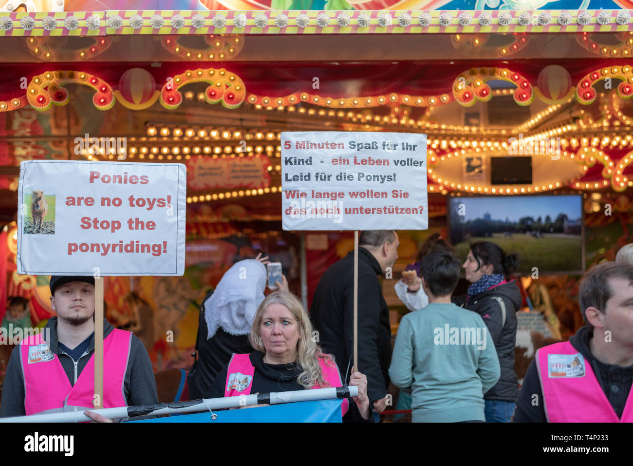 Hamburg, Germany  - People holding banners protesting against pony rides at Hamburger amusement park DOM Stock Photo
