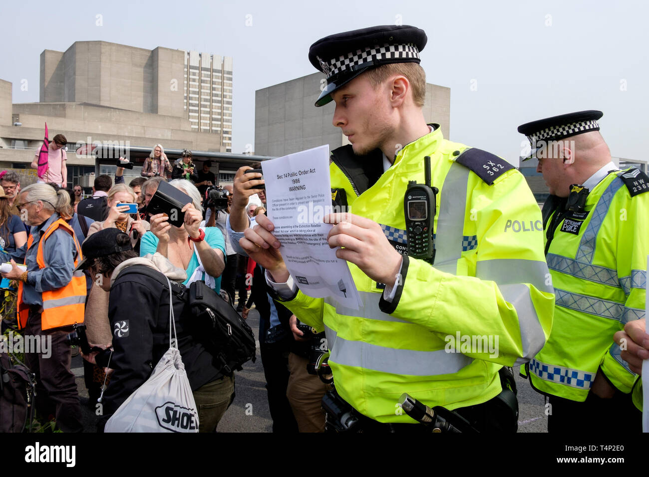 Extinction Rebellion activists occupy Waterloo Bridge, April 2019: Police officer with notice of Section 14 of Public Order Act. Stock Photo