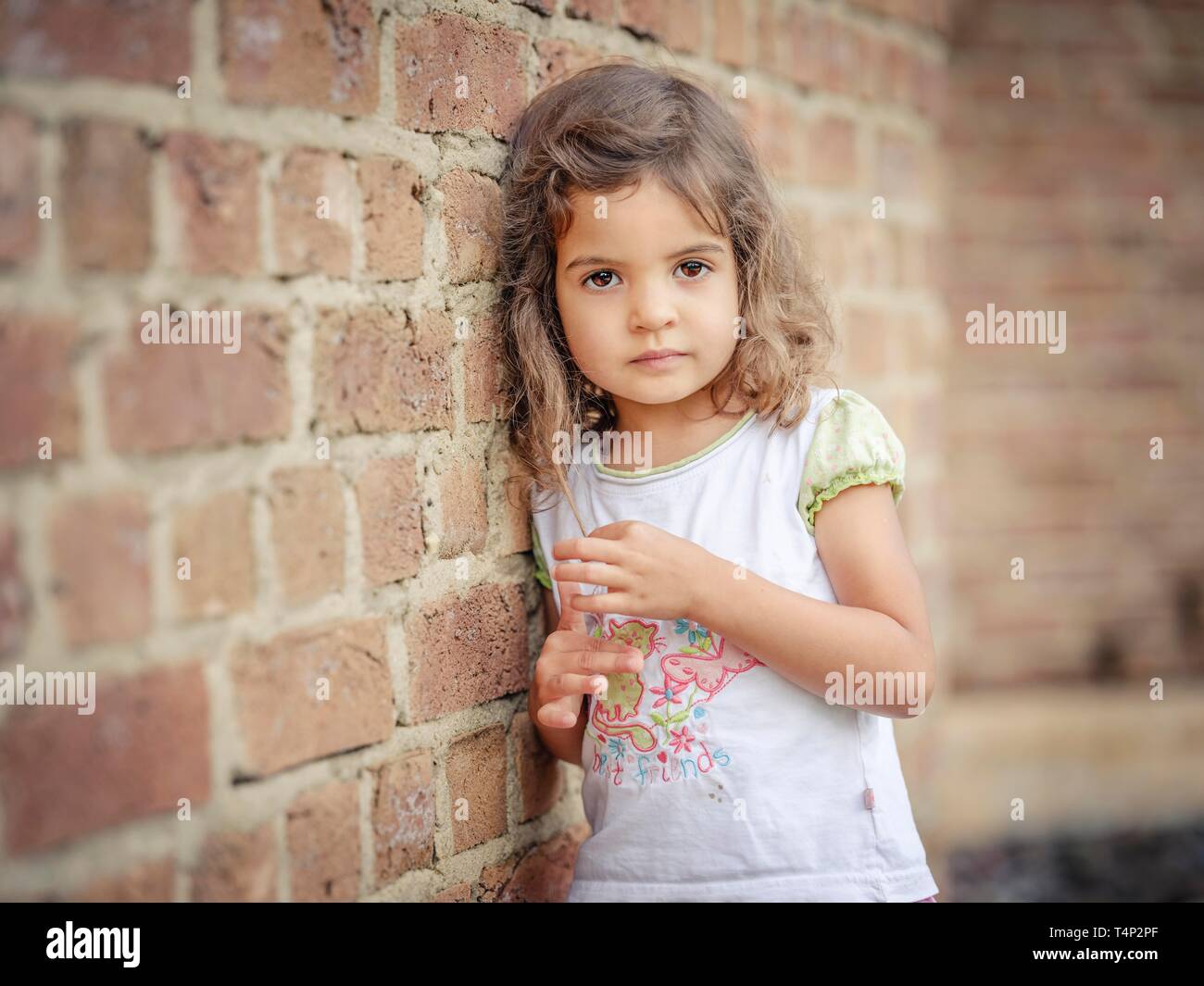 Girl, 3 years old, leaning against a wall, portrait, Germany Stock Photo