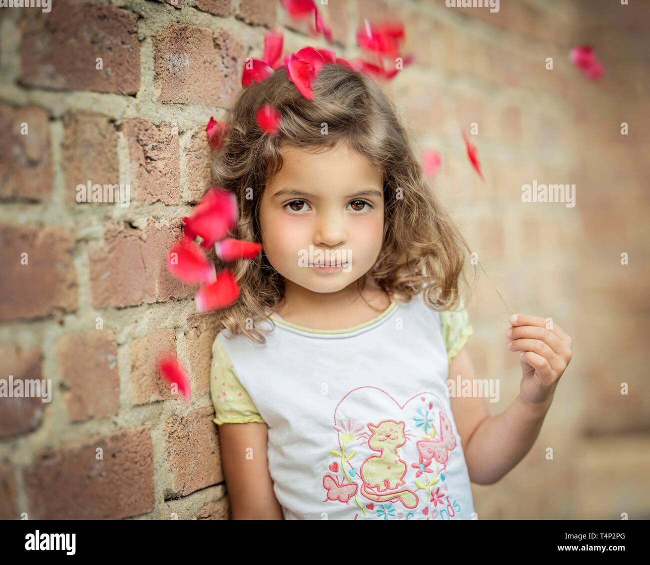 Girl, 3 years old, leans against a wall under flowers, Portrait, Germany Stock Photo
