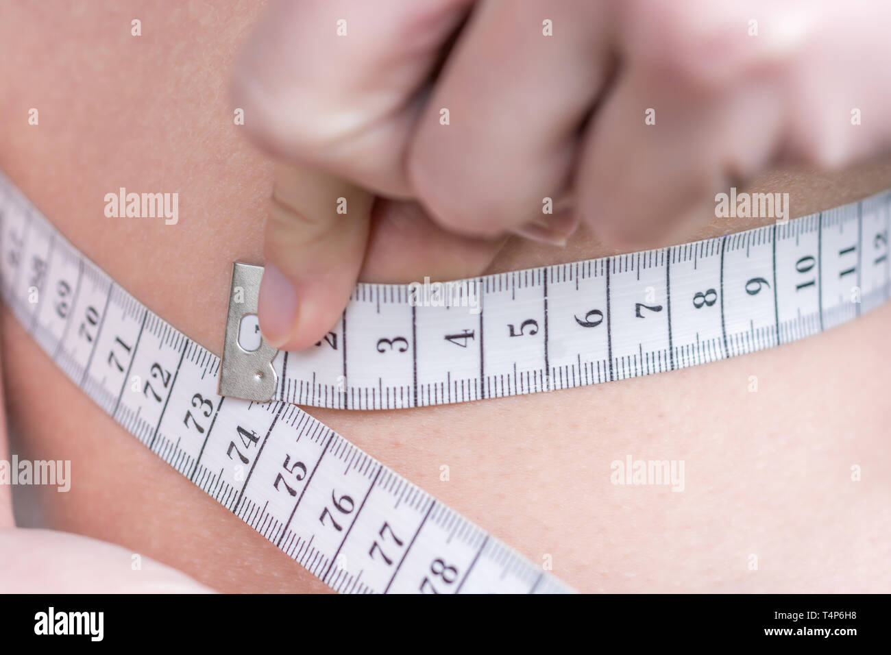Woman measures waist with measuring tape Stock Photo