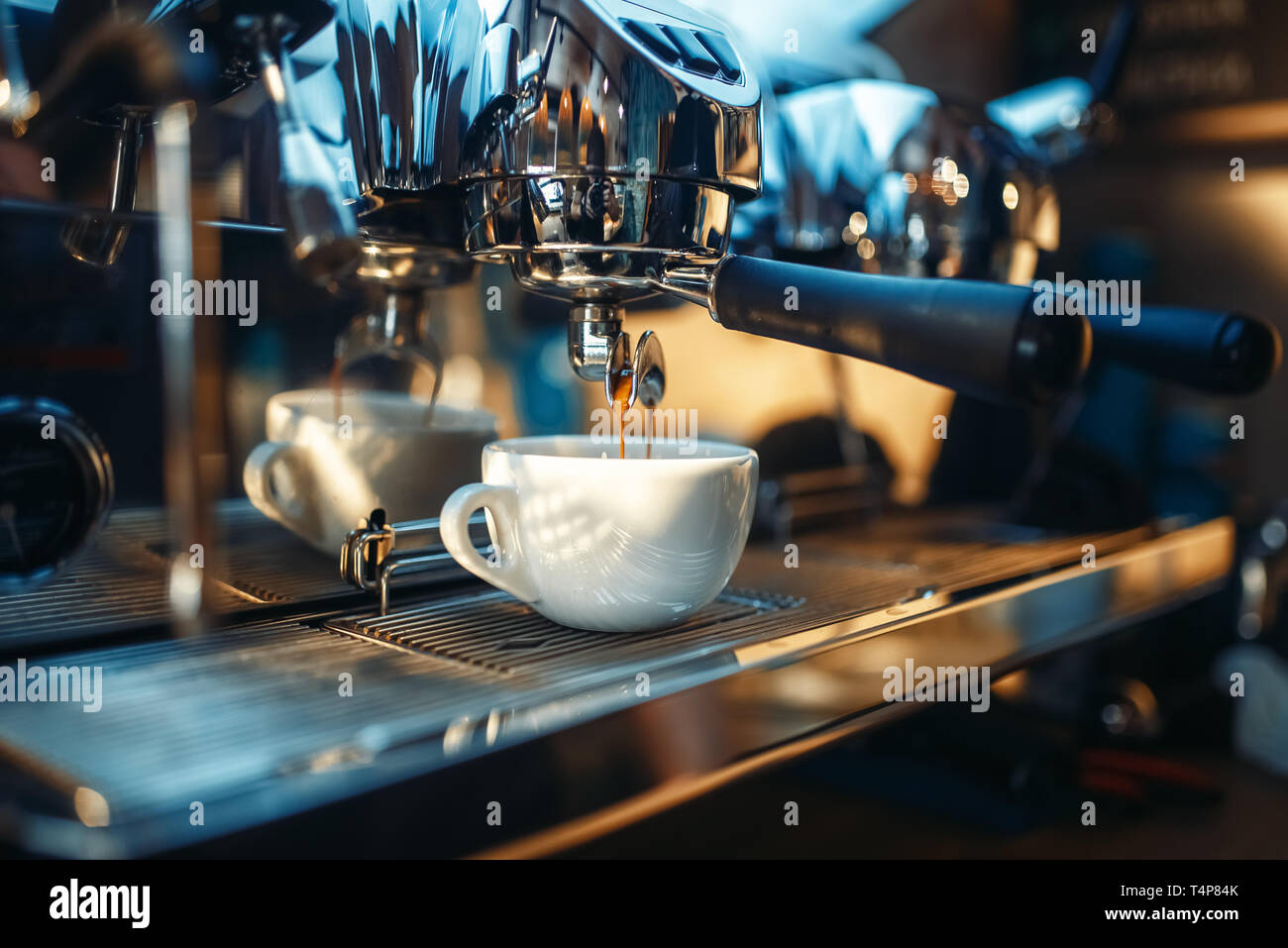 Espresso machine pours fresh black coffee into the cup closeup
