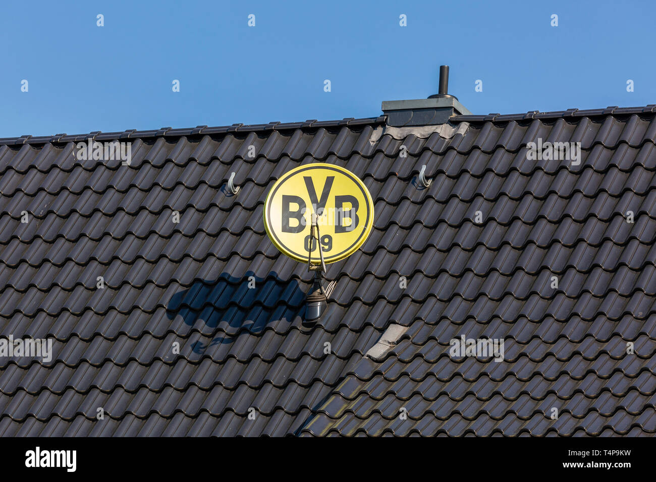 symbolic image, parabolic antenna in club colours and with club emblem of the German football club BVB 09 Borussia Dortmund on a house roof, television aerial, satellite TV, sports, football, Bundesliga, football mania, club loyalty, roofing tiles Stock Photo