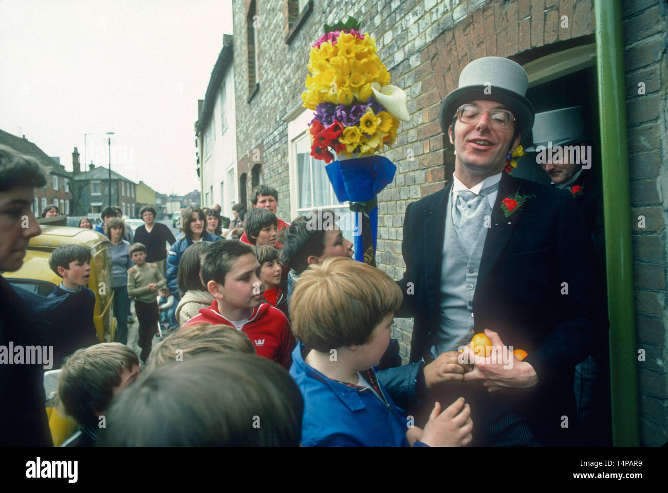 Children surround a Tuttiman for oranges at Hungerford Hocktide, UK in 1982 Stock Photo