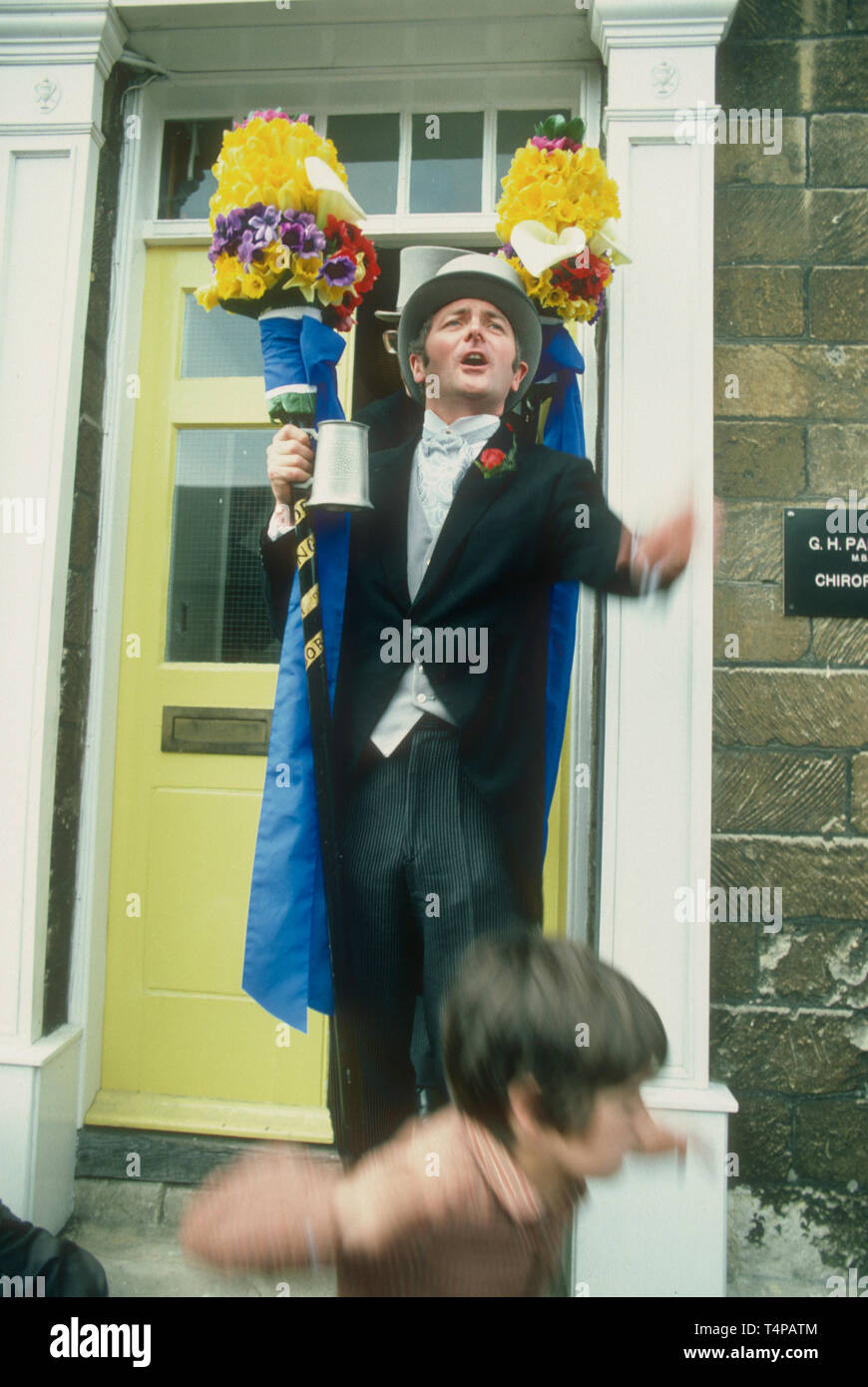 A Tuttiman throws coins to the crowd of children at Hungerford Hocktide, UK in 1982 Stock Photo