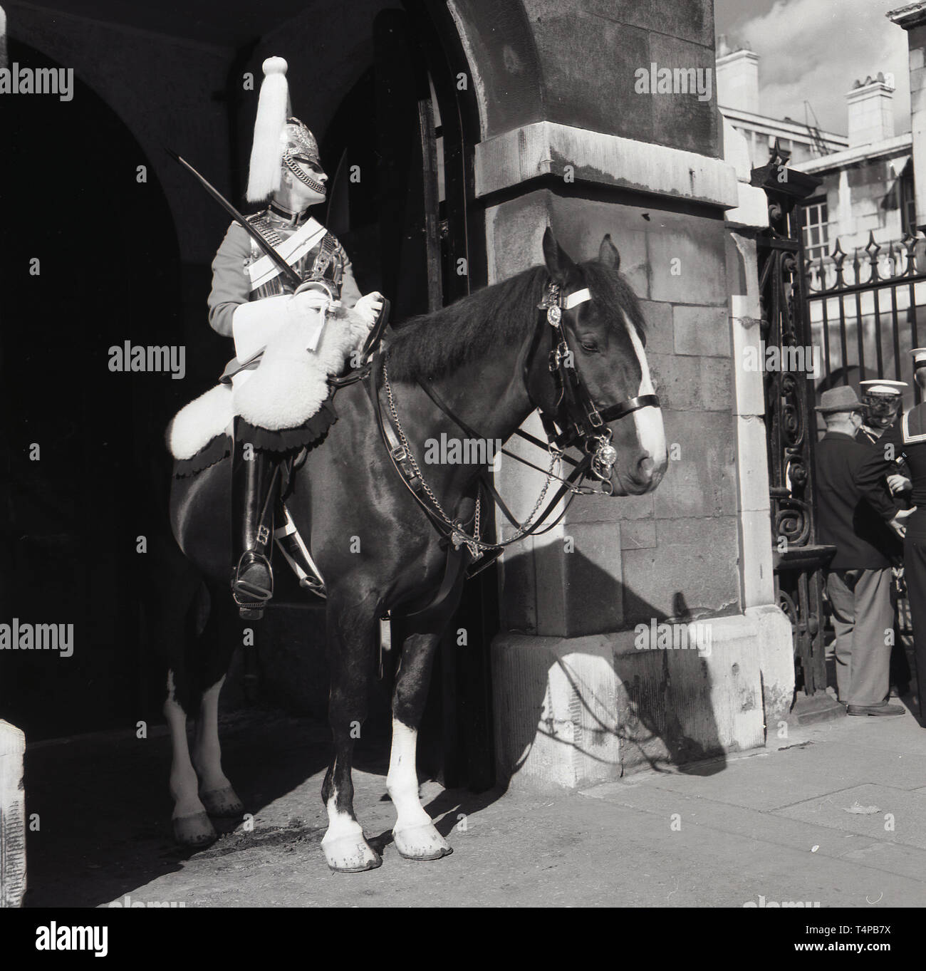 1960s, historical, London, Summer time and a Life Guard of the Household Cavalry mounted reigment in full ceremonial uniform sitting on his horse doing on sentry duty, Stock Photo