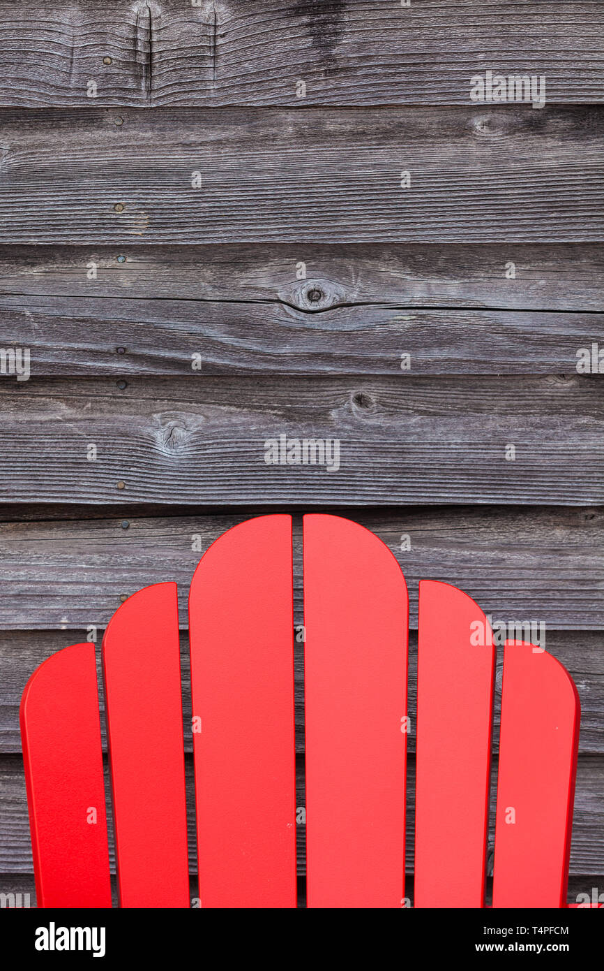 Back support of a Cape Cod chair against weathered cedar siding of a heritage building Stock Photo