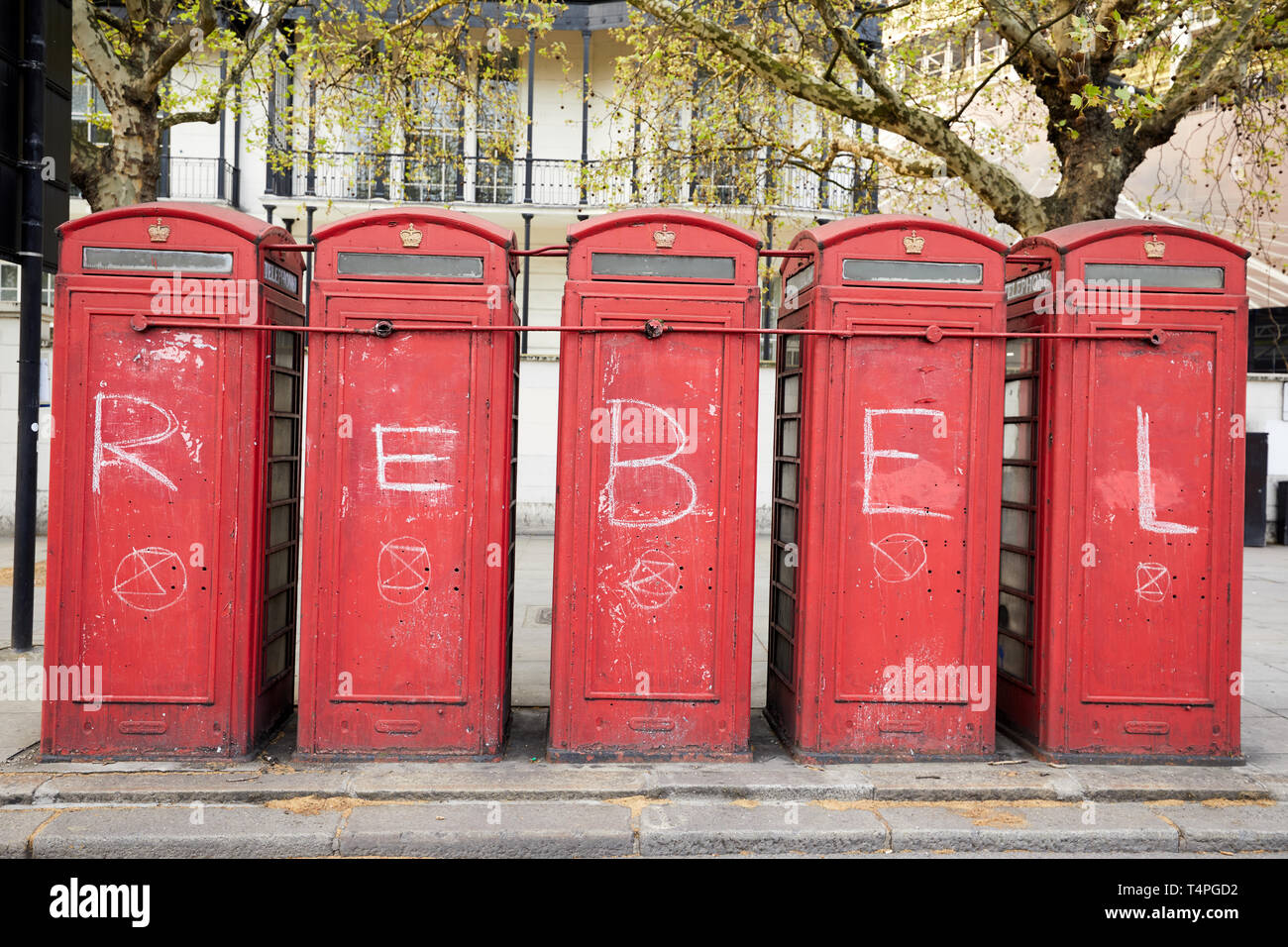 London, UK. - April 17, 2019: Five teleophone kiosks daubed in symbols of the campaign group Extinction Rebellion during a series of protests in the c Stock Photo