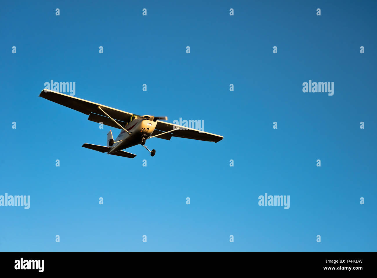 Small airplane approaching for landing with blue sky Stock Photo