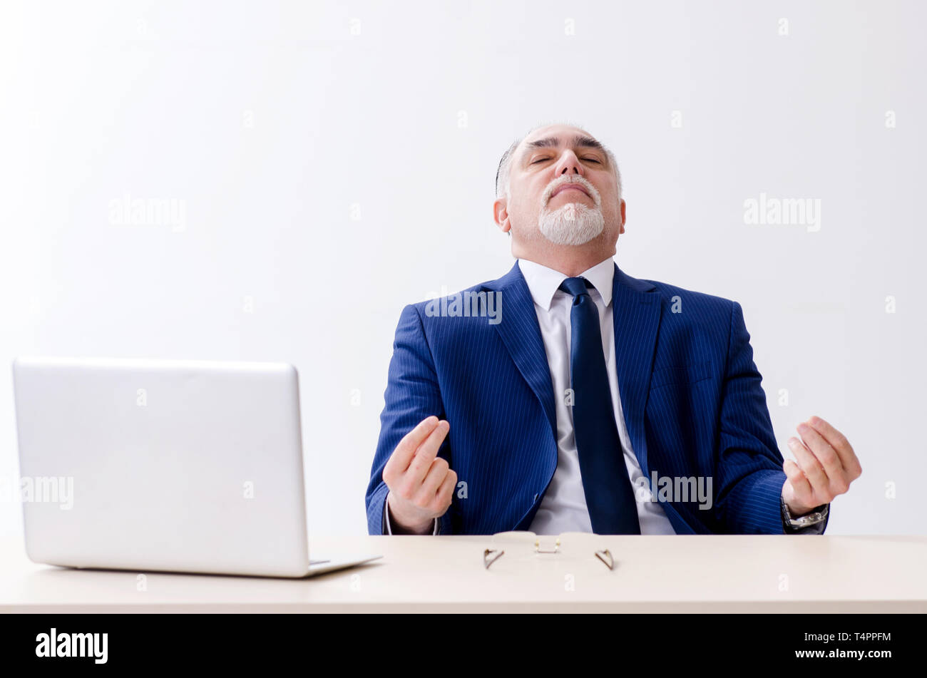 Aged businessman doing yoga exercises in the office Stock Photo - Alamy