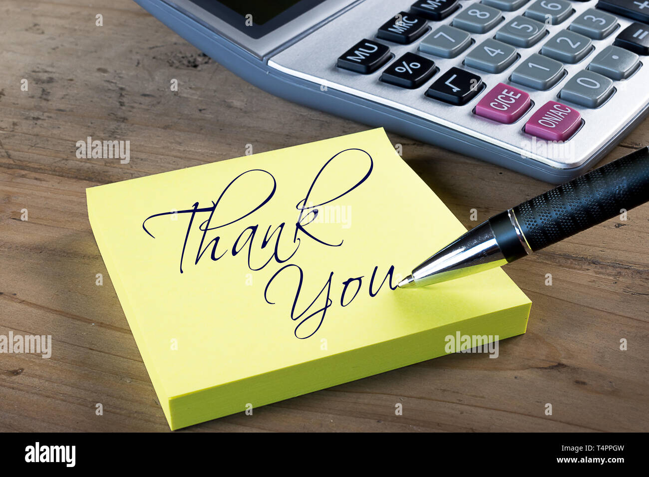 Yellow sticky note with 'Thank you' written with pen. Administrative Professionals or Secretaries day concept. Stock Photo