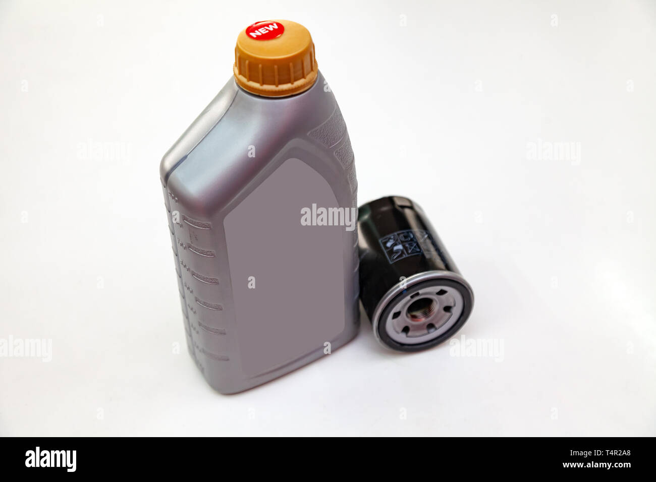 Spare part for car engine  filter for cleaning dust and dirt with one liter bottle or can of lubricant on a white isolated background. Maintenance and Stock Photo