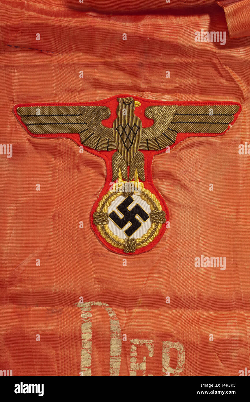 Adolf Hitler - a personal funeral sash as commander-in-chief of the Wehrmacht Red watered artificial silk edged with a gold fringe, one end bearing a national eagle appliquéd in gold embroidery on red cloth above an inscription in gold reading 'Der Führer', the other end with appliquéd 'Führerstandarte' in gold embroidery on ribbed silk. Somewhat faded. Total length circa 400 cm, width 27 cm. Extremely rare, completely preserved funeral sash, this size is virtually unheard of except at funerals to honour war heroes killed in action such as Werner Mölders. historic, historic, Editorial-Use-Only Stock Photo