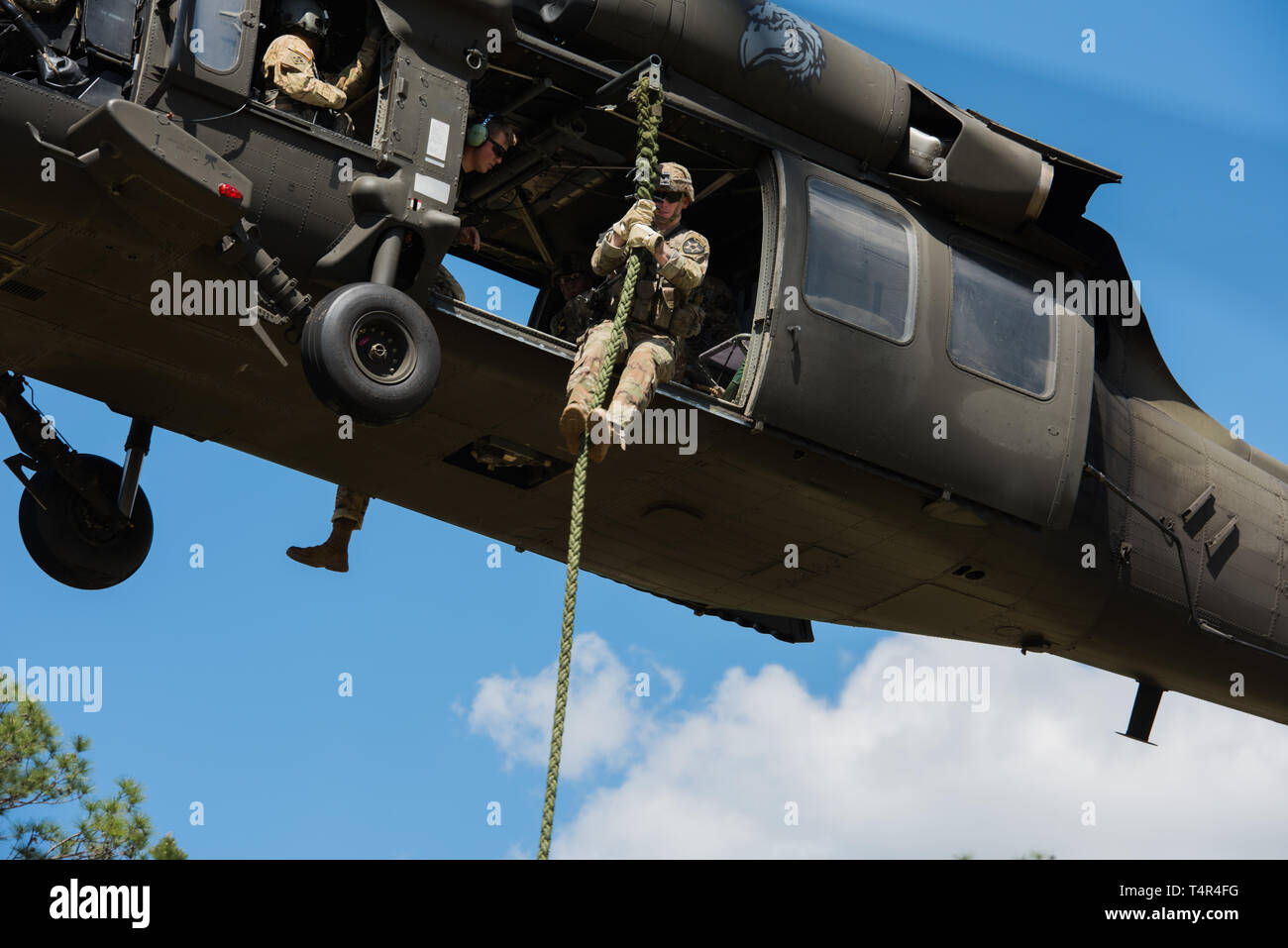 U.S. Army Rangers fast rope from a helicopter in preparation for the ...