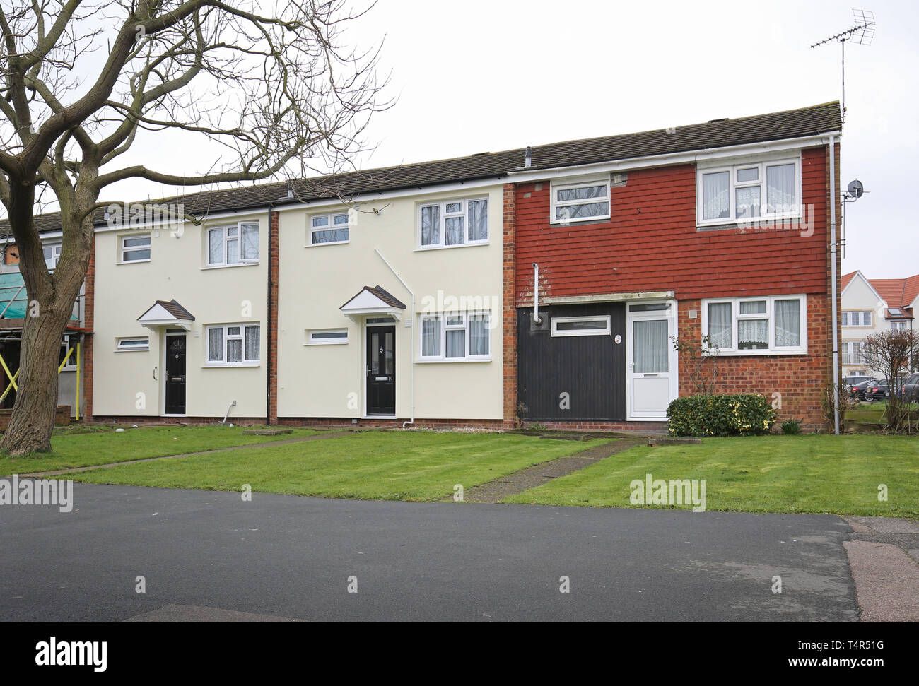 Houses on a 1970s council estate in Basildon, UK, showing newly installed external insulation (in white), next to homes who opted to not have it. Stock Photo