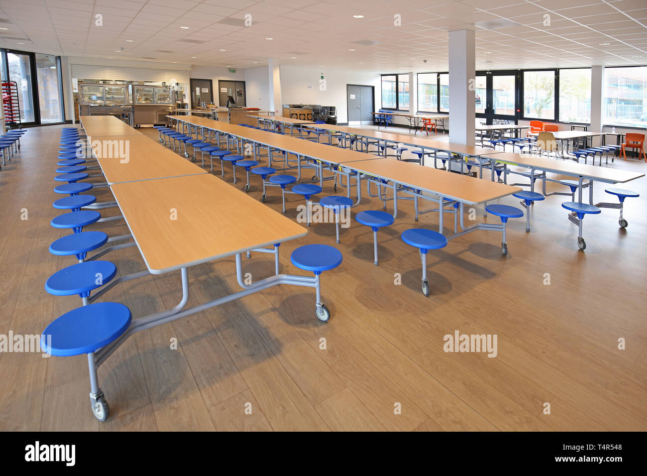 Dining hall in a new academy school, west London, UK. Shows folding tables in place. Building was converted from a 1970s-built office block. Stock Photo