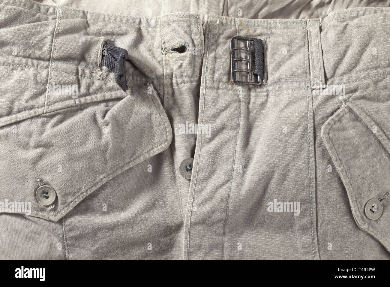 A light special clothing issue outfit of panzer or assault gun units depot piece Unlined tunic of field-grey cotton cloth with light cardboard buttons in special clothing issue cut, however with a slanted double covered fly and left-sided large superimposed front pocket with closure flap, underarm ventilation holes and reinforced side seam openings for a belt. BeVo eagle, silhouettes of collar tabs. The trousers of same material with field-grey cardboard buttons, integrated black web belt and covered fly, both front pockets of unlike size and integrated at different angles,, Editorial-Use-Only Stock Photo
