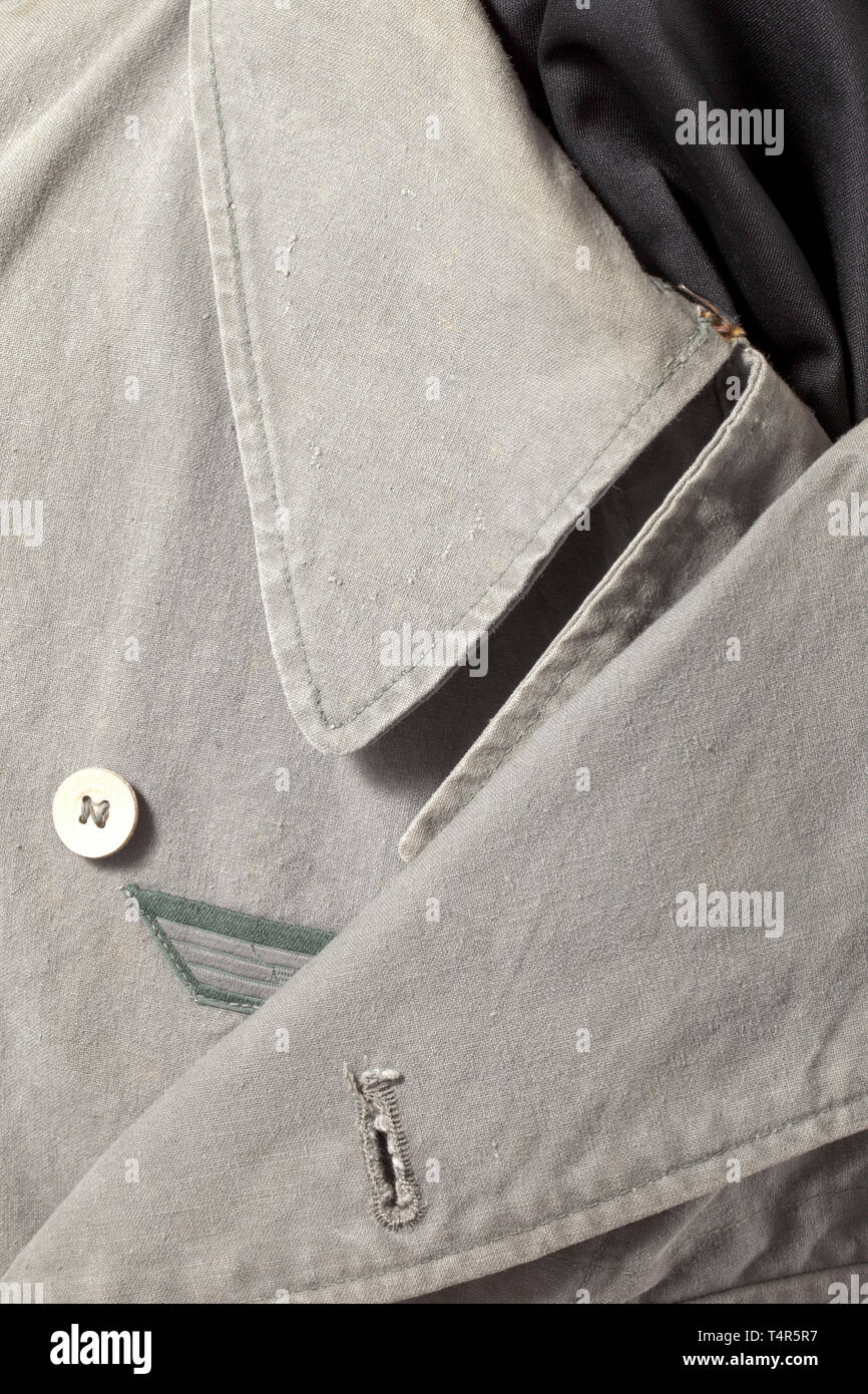 A light special clothing issue outfit of panzer or assault gun units depot piece Unlined tunic of field-grey cotton cloth with light cardboard buttons in special clothing issue cut, however with a slanted double covered fly and left-sided large superimposed front pocket with closure flap, underarm ventilation holes and reinforced side seam openings for a belt. BeVo eagle, silhouettes of collar tabs. The trousers of same material with field-grey cardboard buttons, integrated black web belt and covered fly, both front pockets of unlike size and integrated at different angles,, Editorial-Use-Only Stock Photo