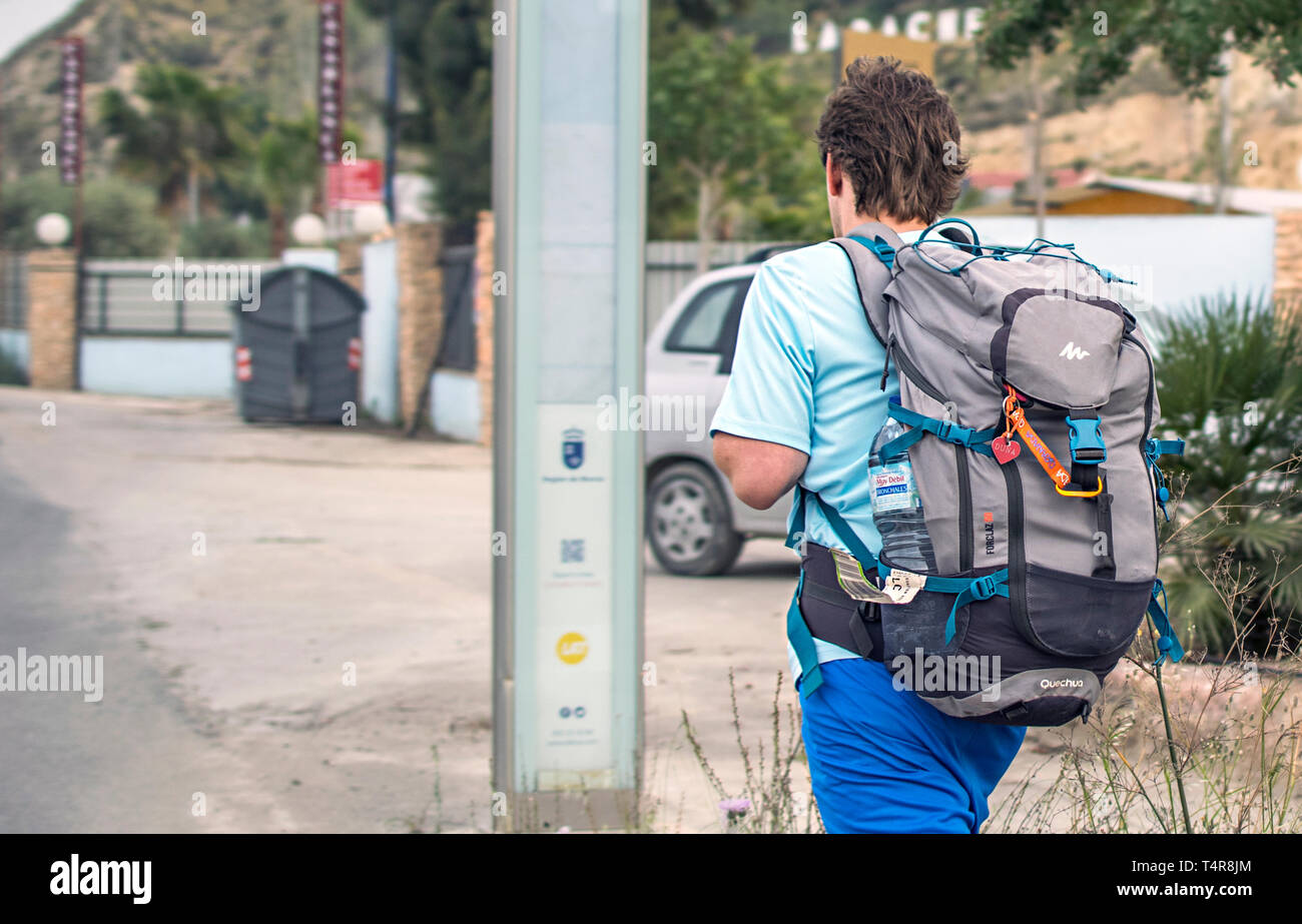 Murcia, Spain, April 17, 2019: Young man wearing huge backpack walking along the street. Adventure abroad. Travel by interrail. Stock Photo