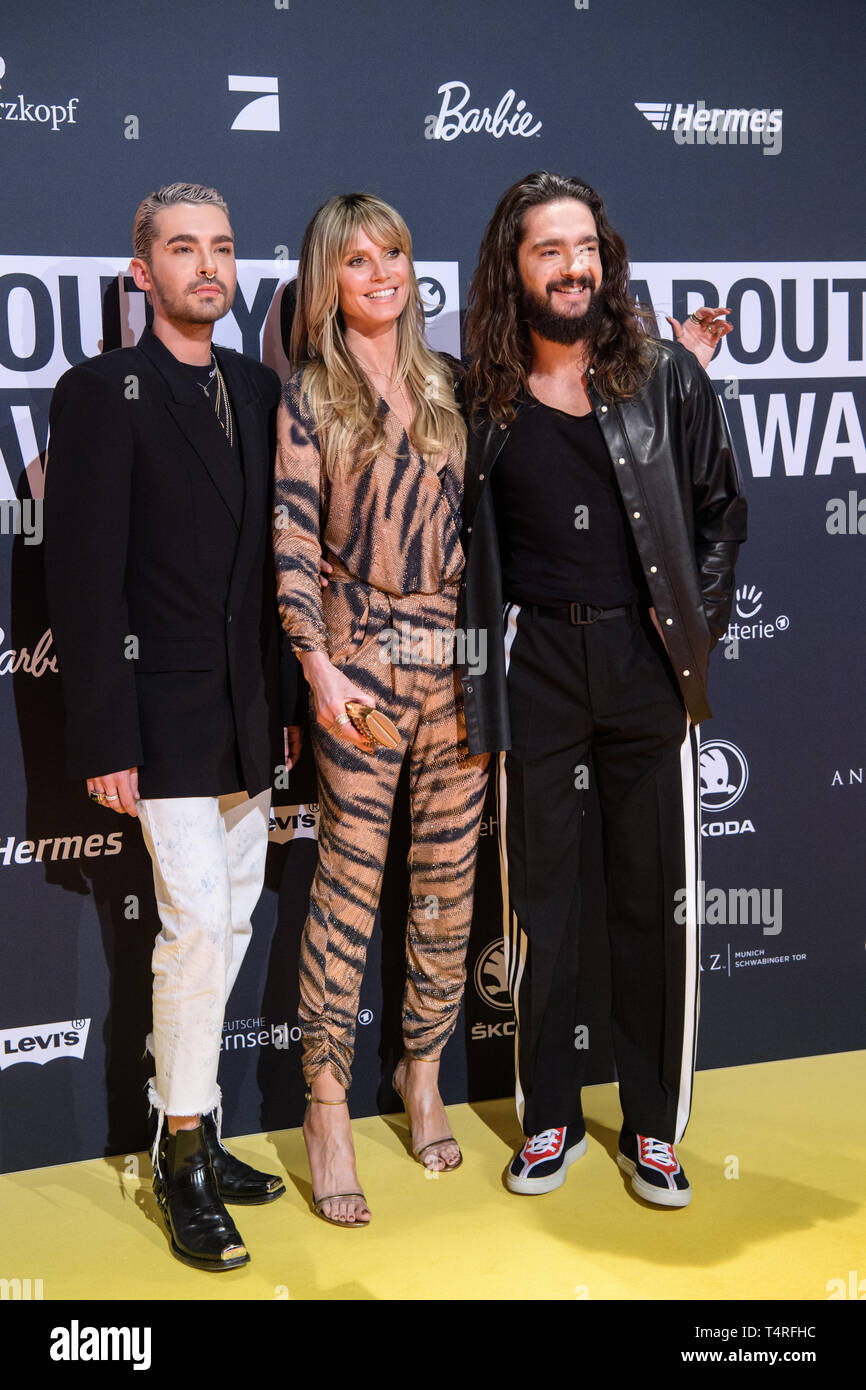 18 April 2019, Bavaria, Grünwald: Bill Kaulitz, singer of the band Tokio  Hotel (l-r), Heidi Klum, model, and her fiancé Tom Kaulitz, singer of the  band Tokio Hotel, come to the presentation