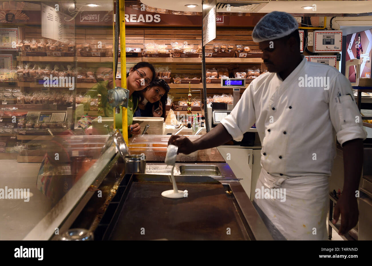 New Delhi, India. 18th Apr, 2019. An Indian chef makes Dosa for a customer at a supermarket in New Delhi, India, April 18, 2019. Dosa, a crispy paper-thin wrap with a spicy potato filling, eaten dipped in a tangy soup and a special sauce or chutney, is popular in southern India. Credit: Zhang Naijie/Xinhua/Alamy Live News Stock Photo
