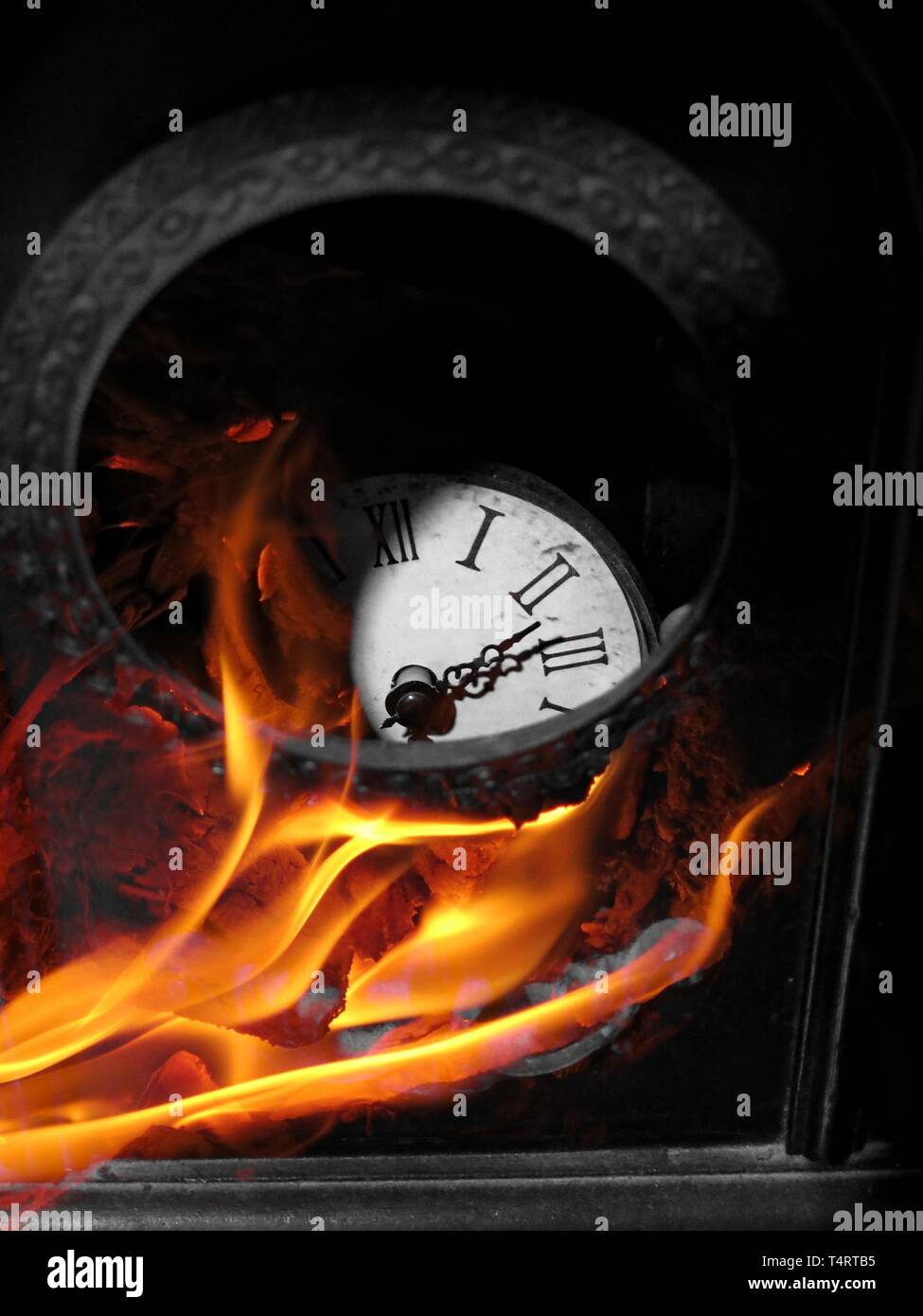 Broken antique clock on fire. Stock Photo