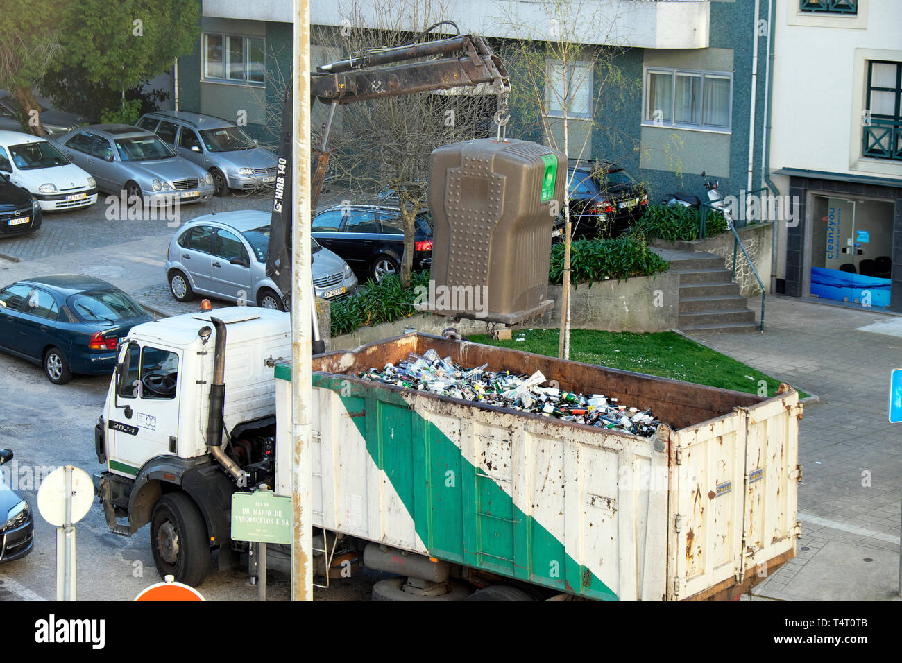 Recycling lorry truck collecting glass wine bottles from recycle bin