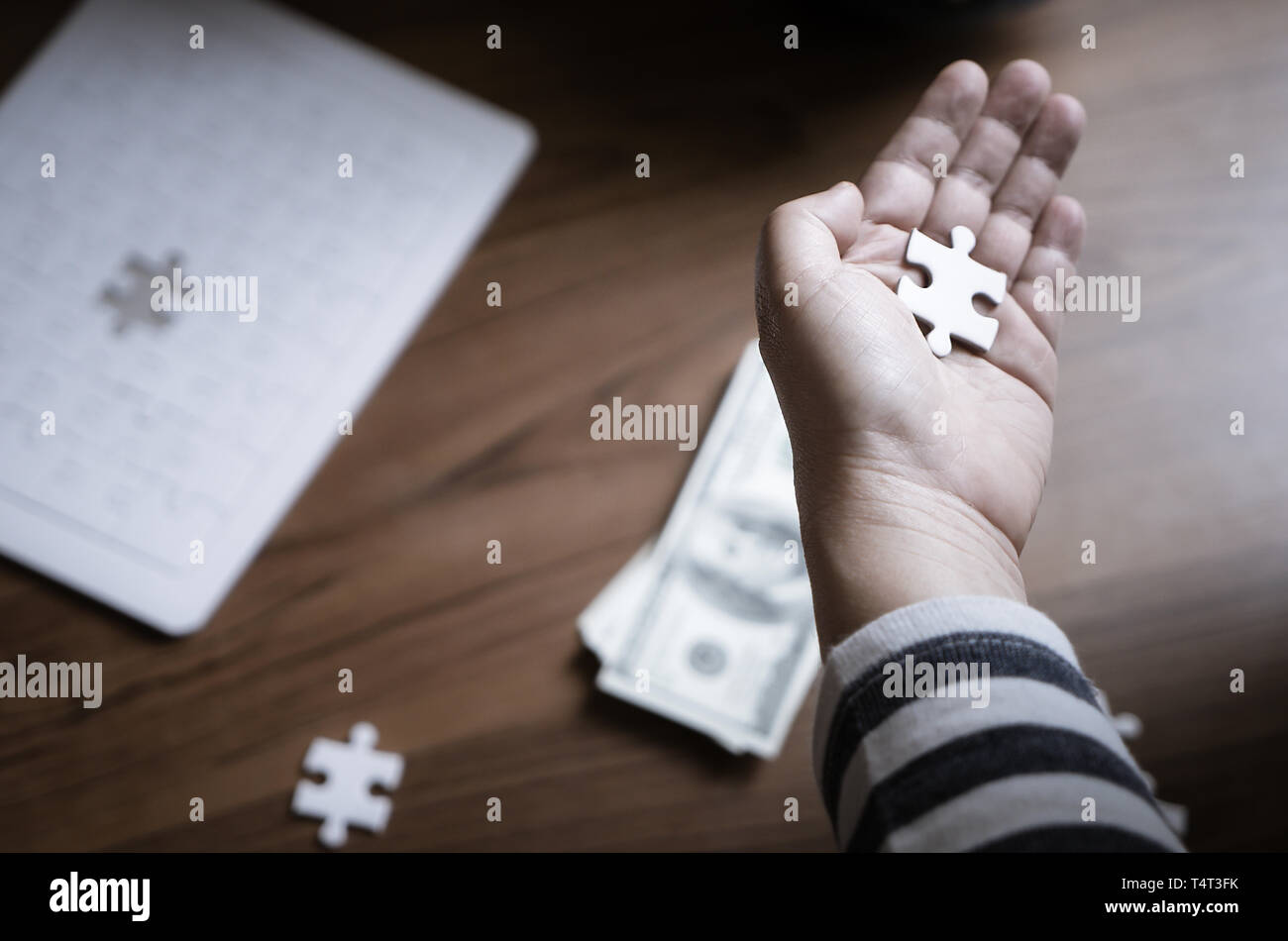 Hand placing last jigsaw for business financial solution Stock Photo