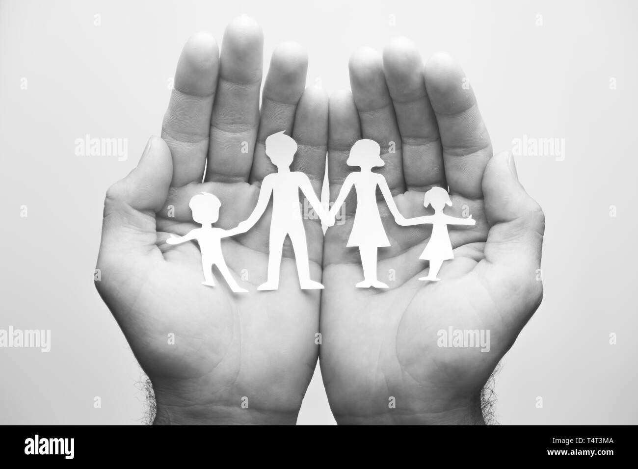 Family Care - Hand holding paper family. Stock Photo