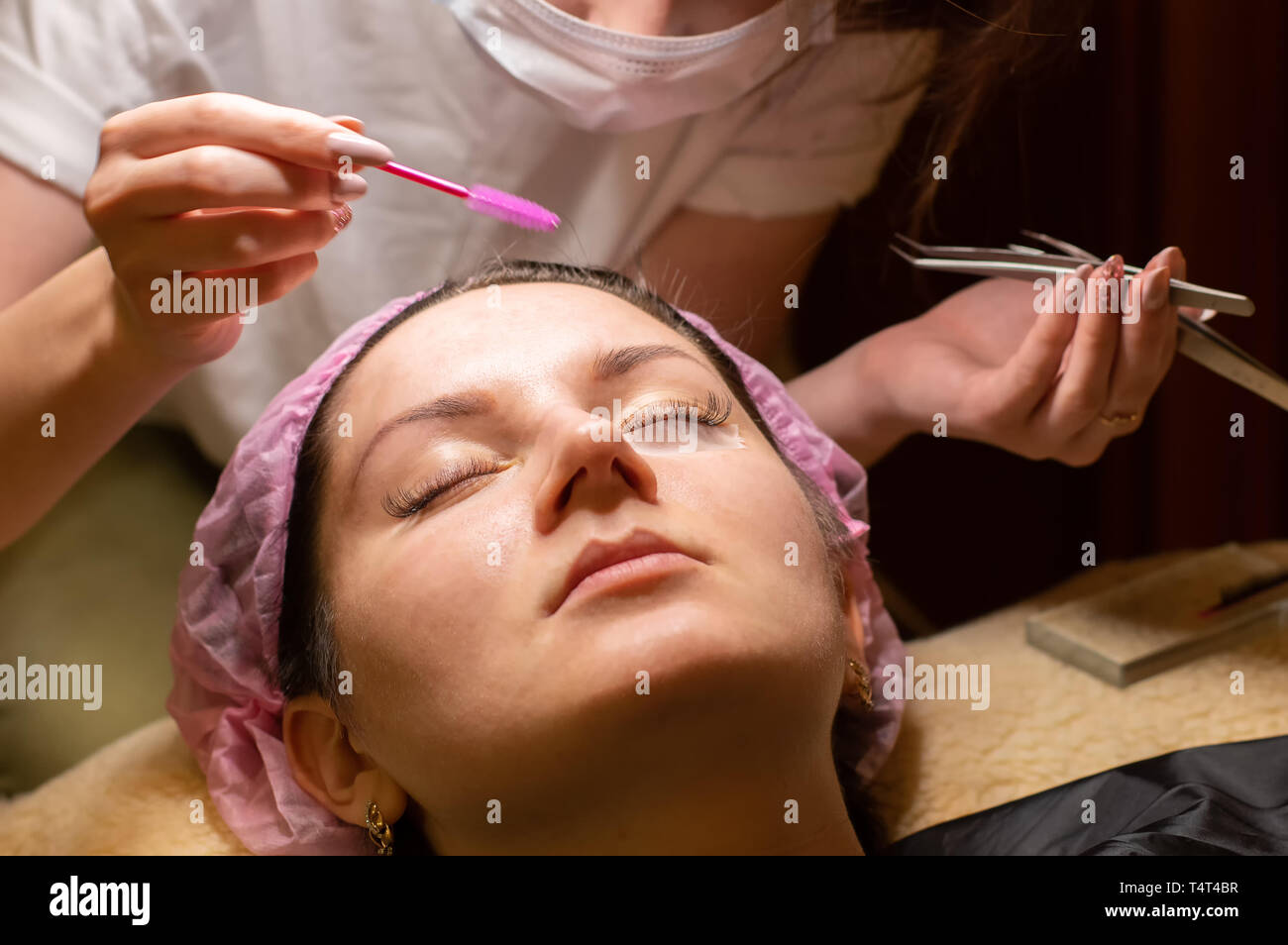 Eyelash extension procedure. Female eye with long eyelashes. Eyelashes, close-up, selective focus Stock Photo