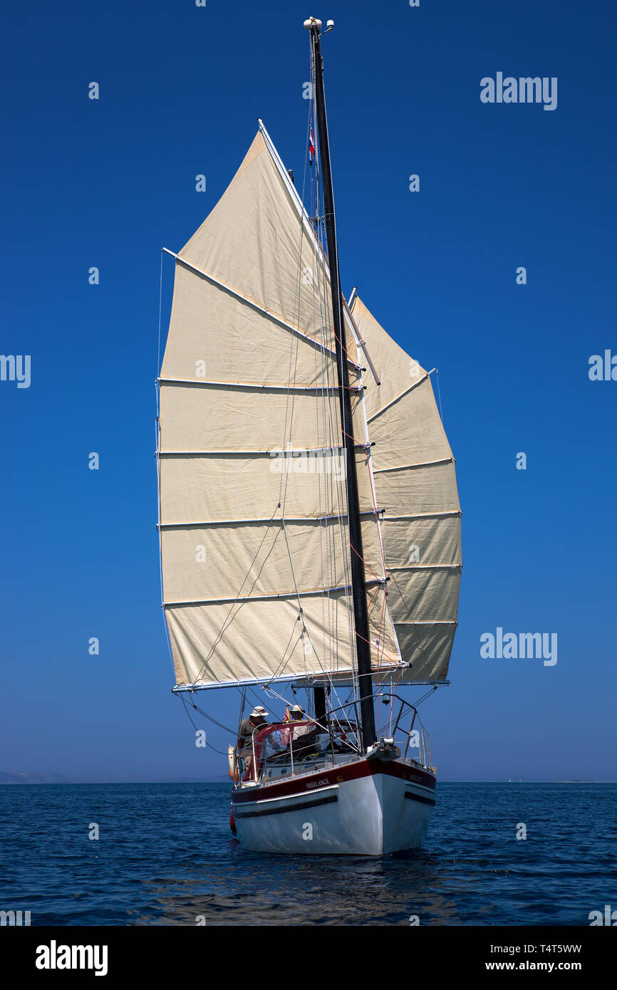 'Freelance', a Freedom 30 junk-rigged ketch, sailing downwind in the Murtersko more (Murter Sea), Adriatic, Šibenik-Knin, Croatia.  MODEL RELEASED Stock Photo