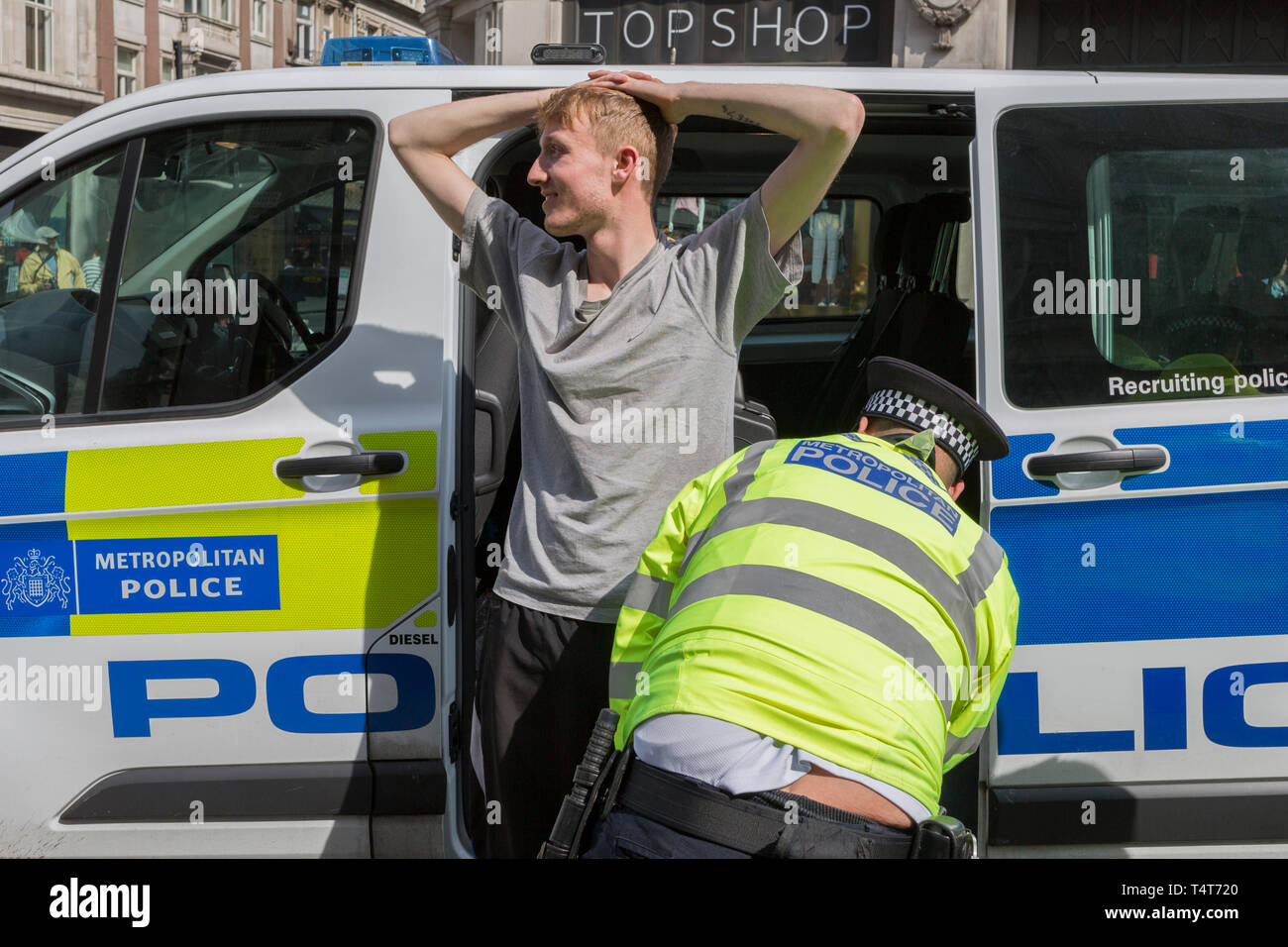 A young male protester is arrested and searched by Met police officers at Oxford Circus on day 4 of protests by climate change environmental activists with pressure group Extinction Rebellion, on18th April 2019, in London, England. Stock Photo