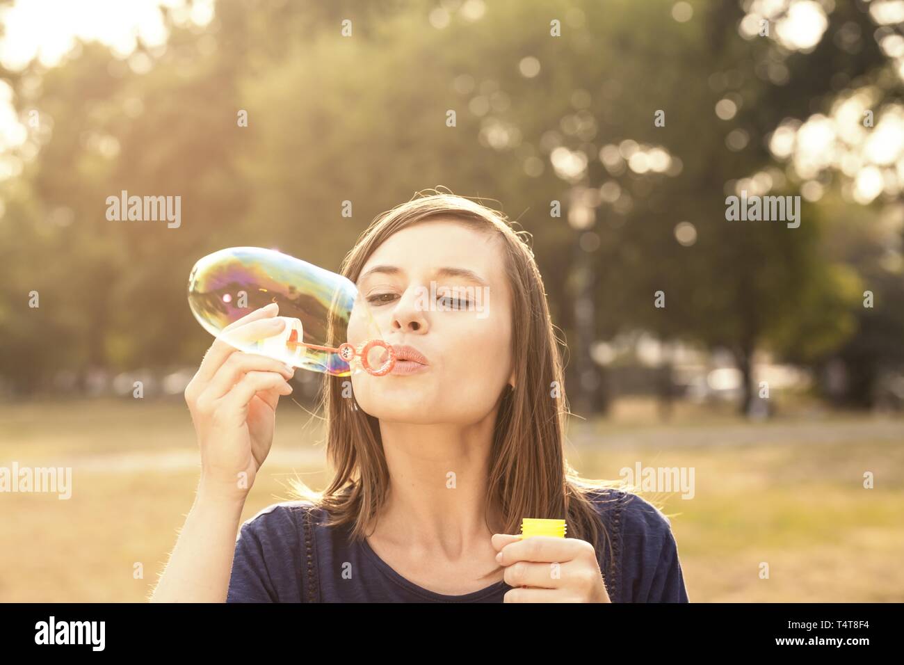 Young woman making soap bubbles, Germany Stock Photo