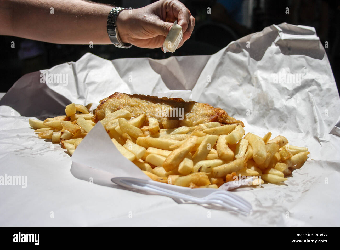 Takeaway fish and chips meal, served on a paper with plastic fork, Australia Stock Photo Alamy