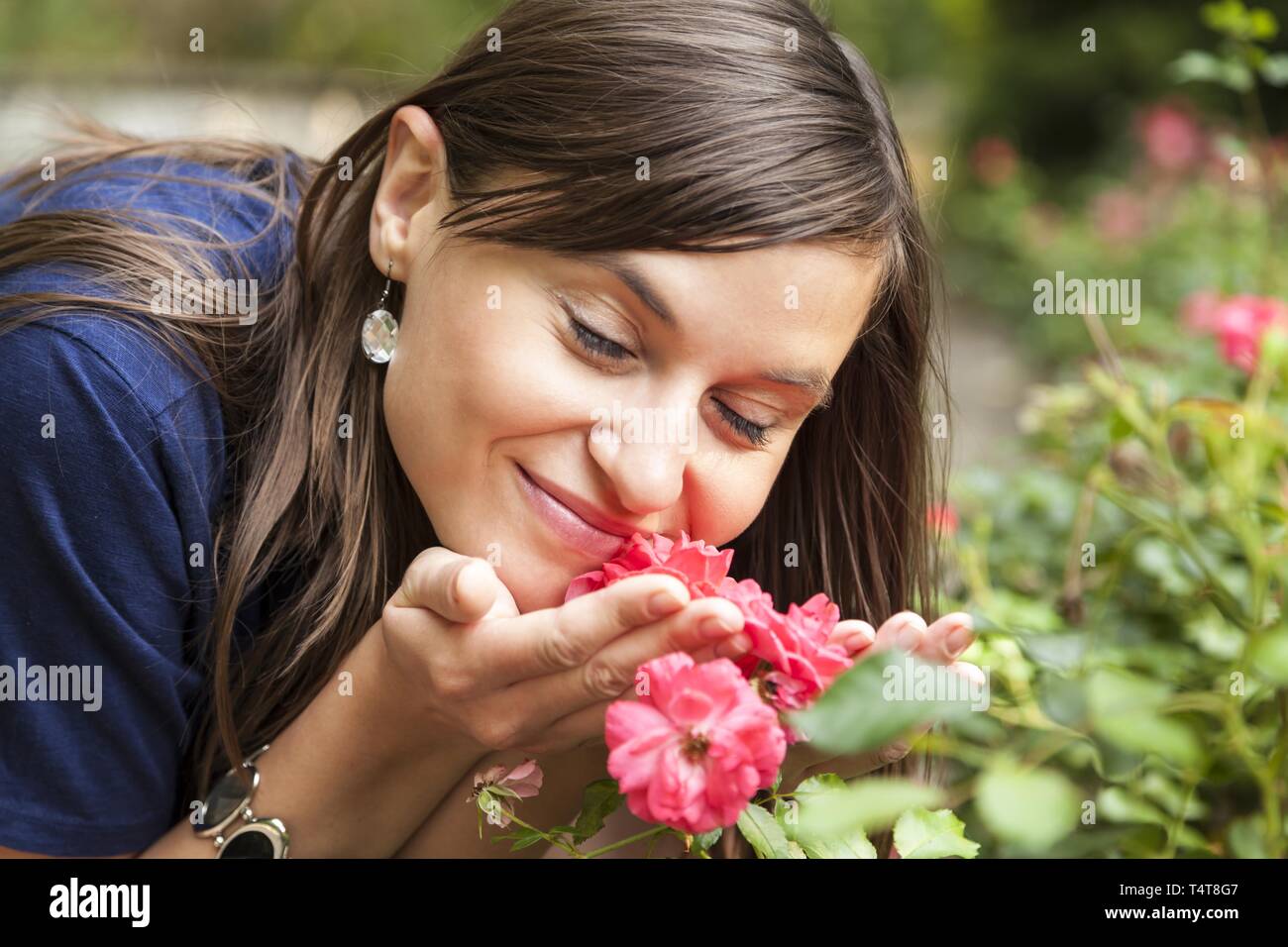 Young woman smelling roses, Germany Stock Photo
