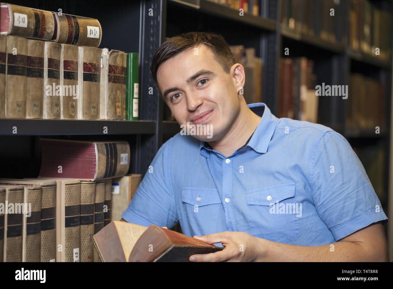 Student reading a book in a library Stock Photo