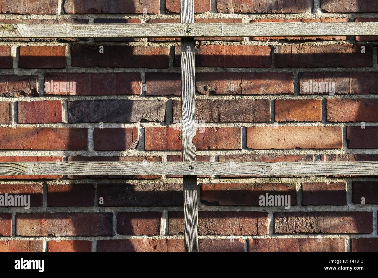 Wooden grid on brick wall Stock Photo